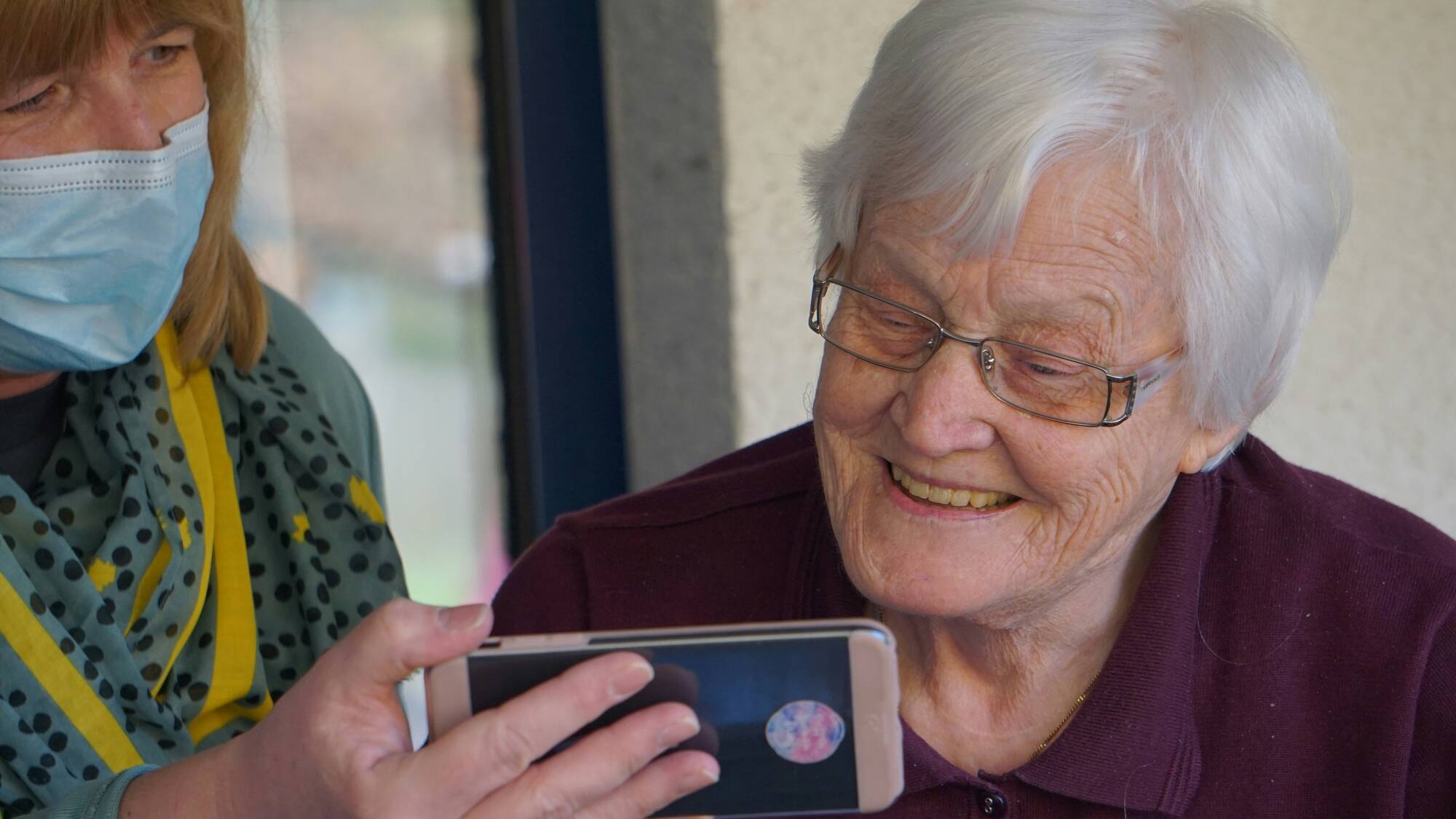 femme montrant un téléphone à une autre femme