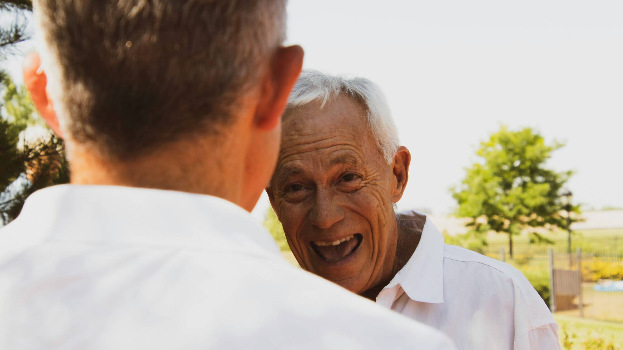 Homme âgé souriant à une personne de dos